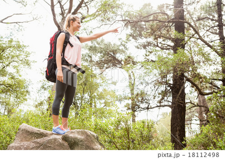 Smiling blonde hiker pointing far away 18112498