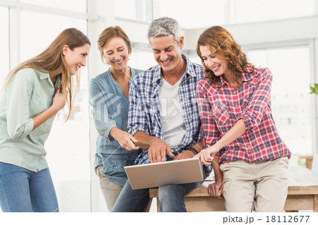 Casual business team having a meeting using laptop Casual business team having a meeting using laptop 18112677