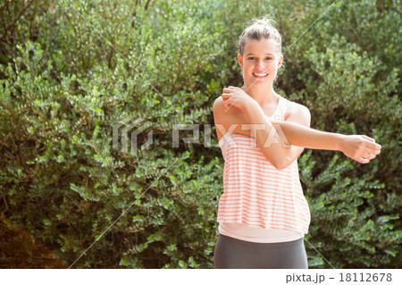 Smiling blonde athlete stretching arms 18112678