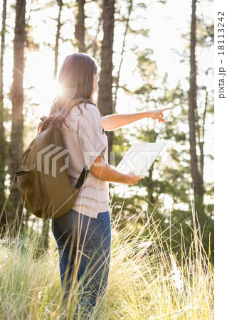 Brunette hiker with map pointing far away 18113242