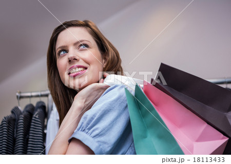 Woman holding shopping bags over shoulderの写真素材 [18113433] - PIXTA