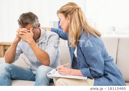 Concerned therapist comforting male patient Concerned therapist comforting male patient 18113460