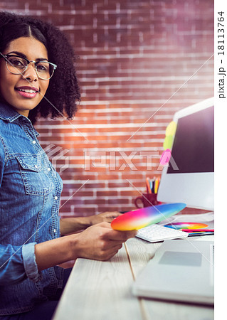 Casual female designer smiling and holding colour chart Casual female designer smiling and holding colour chart 18113764
