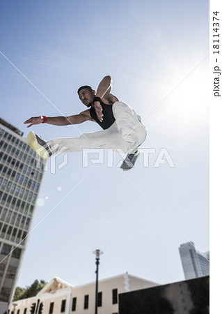 Extreme athlete jumping in front of building Extreme athlete jumping in front of building 18114374