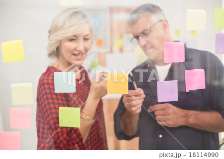 Business team pointing post its on the wall 18114990
