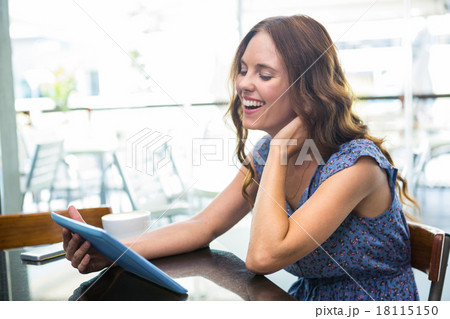 Woman having coffee and using her tablet 18115150