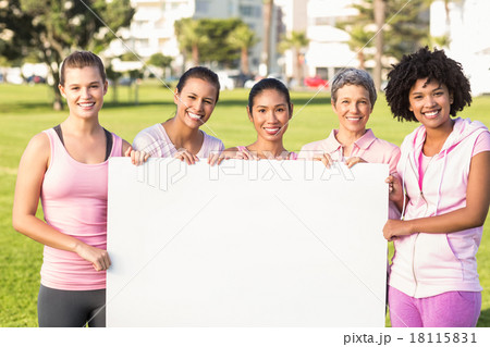 Women wearing pink for breast cancer and holding blank poster Women wearing pink for breast cancer and holding blank poster 18115831