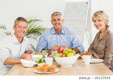 Smiling business colleagues having lunch together Smiling business colleagues having lunch together 18115939