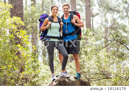 Happy hikers climbing on rock and smiling at camera 18116179