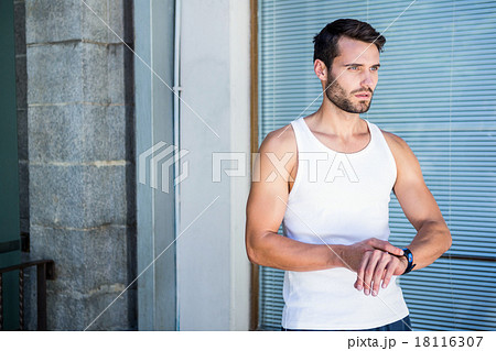 Handsome athlete checking heart rate watch 18116307