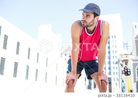 Exhausted athlete leaning forward after an effort Exhausted athlete leaning forward after an effort 18116410
