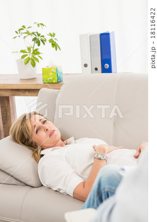 Unhappy woman lying on couch and talking to therapist 18116422