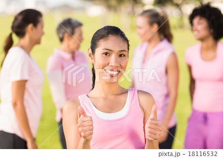 Smiling woman wearing pink for breast cancer in front of friends Smiling woman wearing pink for breast cancer in front of friends 18116532