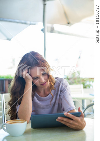 Woman using tablet on cafe terrace 18116727