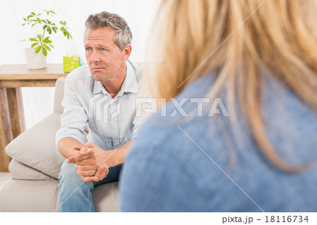 Worried man sitting on couch and talking to therapist Worried man sitting on couch and talking to therapist 18116734