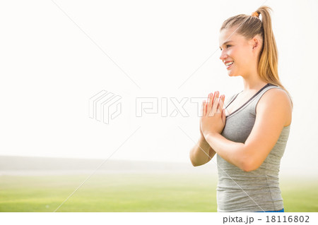 Smiling sporty blonde meditating 18116802