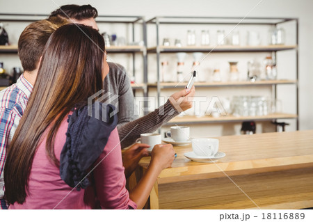 Group of friends looking at a smartphone Group of friends looking at a smartphone 18116889