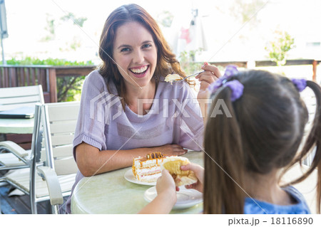 Mother and daughter enjoying cakes at cafe terrace Mother and daughter enjoying cakes at cafe terrace 18116890