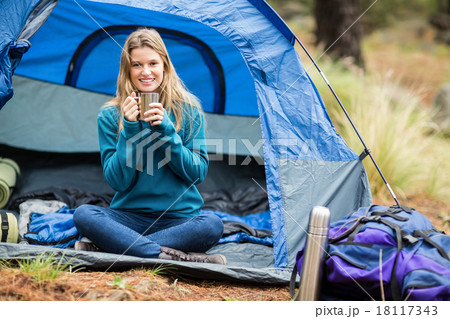 Portrait of a young pretty hiker sitting in a tent 18117343