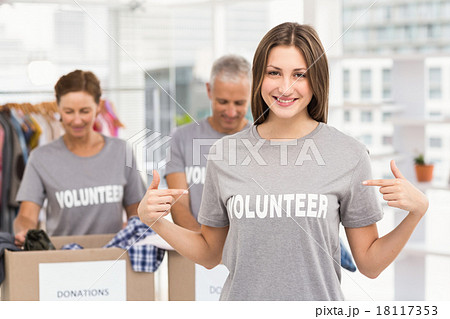 Smiling female volunteer pointing on shirt 18117353