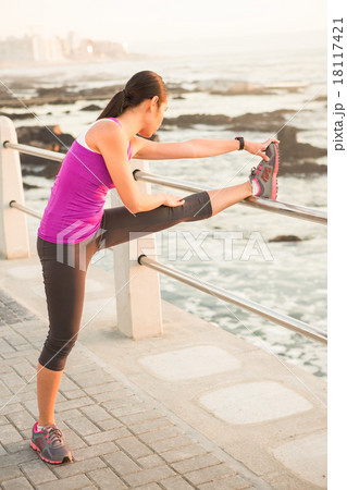Fit woman stretching leg on railing Fit woman stretching leg on railing 18117421