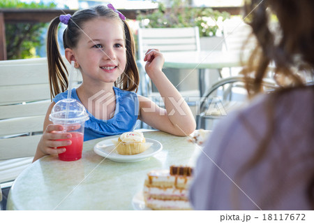 Mother and daughter enjoying cakes at cafe terrace Mother and daughter enjoying cakes at cafe terrace 18117672