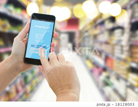 hand holding a modern smartphone in supermarket 18128003