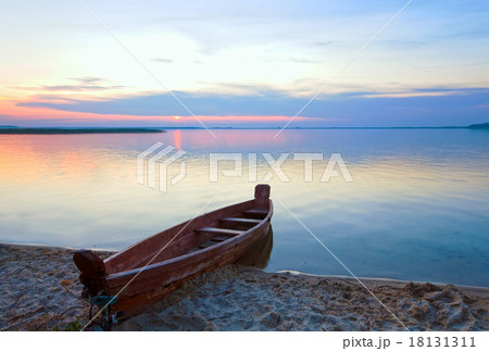 Sunset with boat near the summer lake shore 18131311