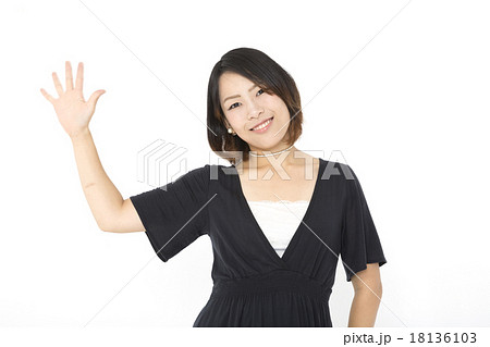 若い女性 ポーズ 笑顔で手を振るの写真素材