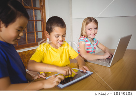 Cute pupils in class using laptop and tablet 18140102