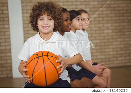 Student holding basketball with fellow players Student holding basketball with fellow players 18140236