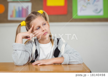 Thoughtful pupil sitting at her desk in a classroom Thoughtful pupil sitting at her desk in a classroom 18140498