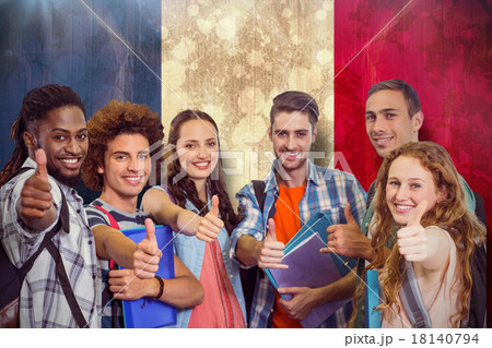 Composite image of smiling group of students doing thumbs up 18140794