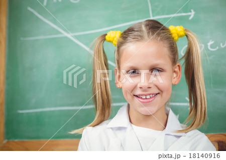 Cute pupil with lab coat in front of chalkboard Cute pupil with lab coat in front of chalkboard 18140916