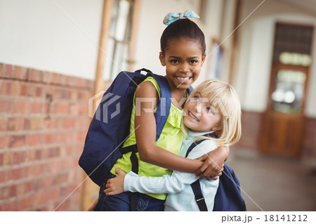 Cute pupils embracing at corridor Cute pupils embracing at corridor 18141212