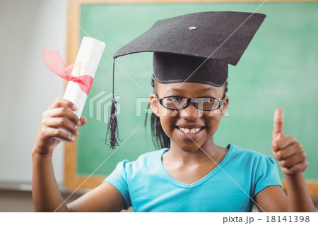 Smiling pupil with mortar board doing thumbs up Smiling pupil with mortar board doing thumbs up 18141398