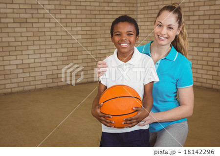 Student holding basketball with teacher Student holding basketball with teacher 18142296