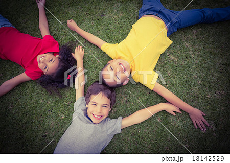 Cute pupils lying on grass smiling 18142529