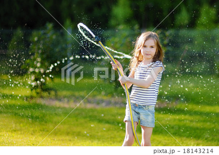 Adorable little girl playing with a garden hose 18143214