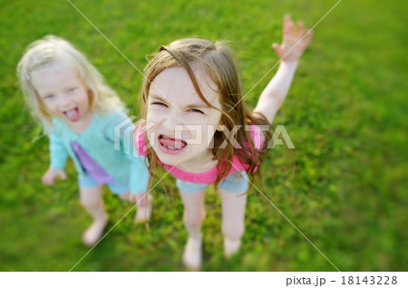 Two little sisters making funny faces Two little sisters making funny faces 18143228