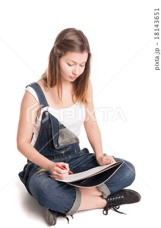 Young woman happily sitting cross-legged on the Young woman happily sitting cross-legged on the 18143651