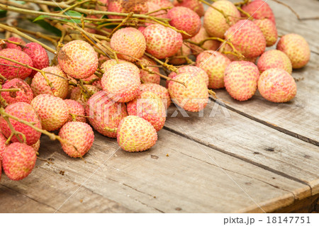 Red litchi on wooden floor Red litchi on wooden floor 18147751