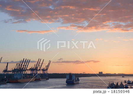 Cranes in a harbor at sunset 18150346