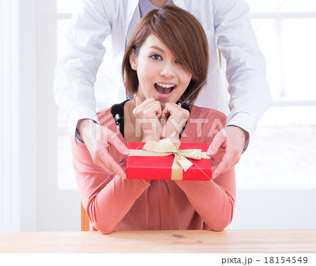 アップ　プレゼントを渡されて驚く若いカップル 18154549