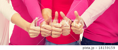 close up of women in pink shirts showing thumbs up 18159159