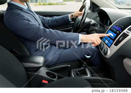 close up of man driving car with board computer 18159366