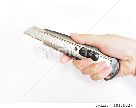 カッターナイフを持つ女性の手の写真素材