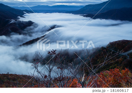 新潟県魚沼市 枝折峠 紅葉の雲海と滝雲の写真素材