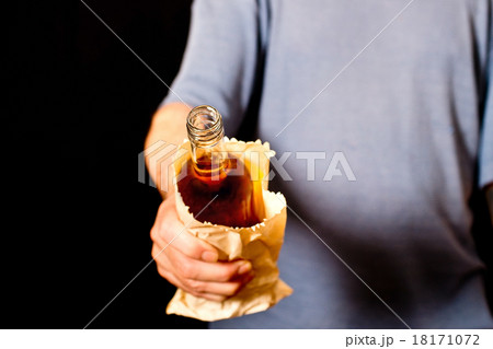 drinker holds a bottle in the paper bag 18171072