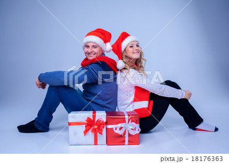 Lovely christmas couple sitting with presents Lovely christmas couple sitting with presents 18176363